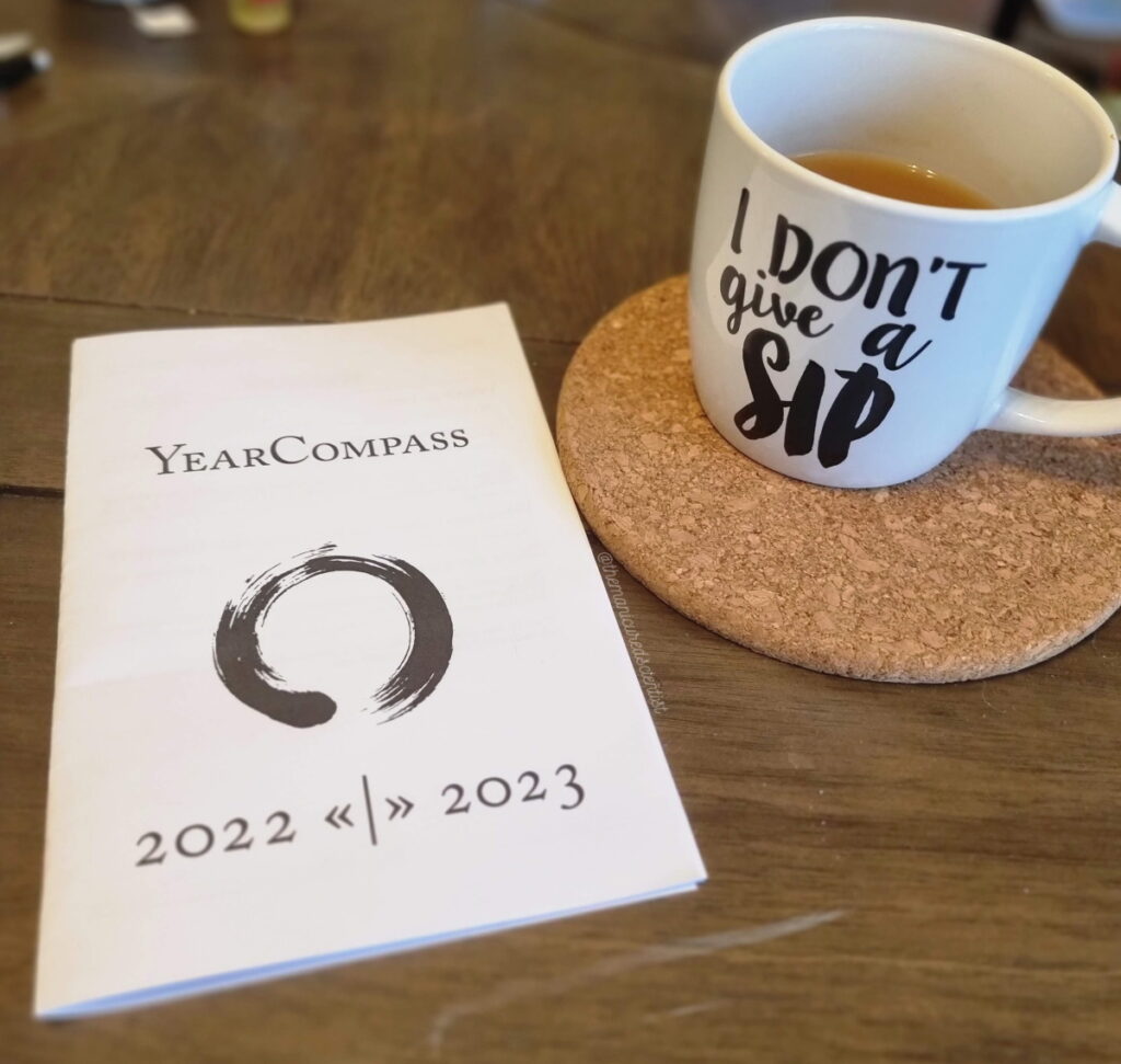 YearCompass booklet sitting next to a cup of tea: one of the techniques I used to set intentions for 2023