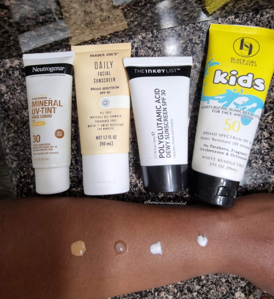 4 sunscreen bottles with a dot of each placed on my arm